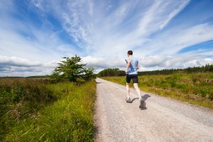 man running down road in the sunlight