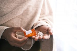 woman pouring prescription pills from a bottle