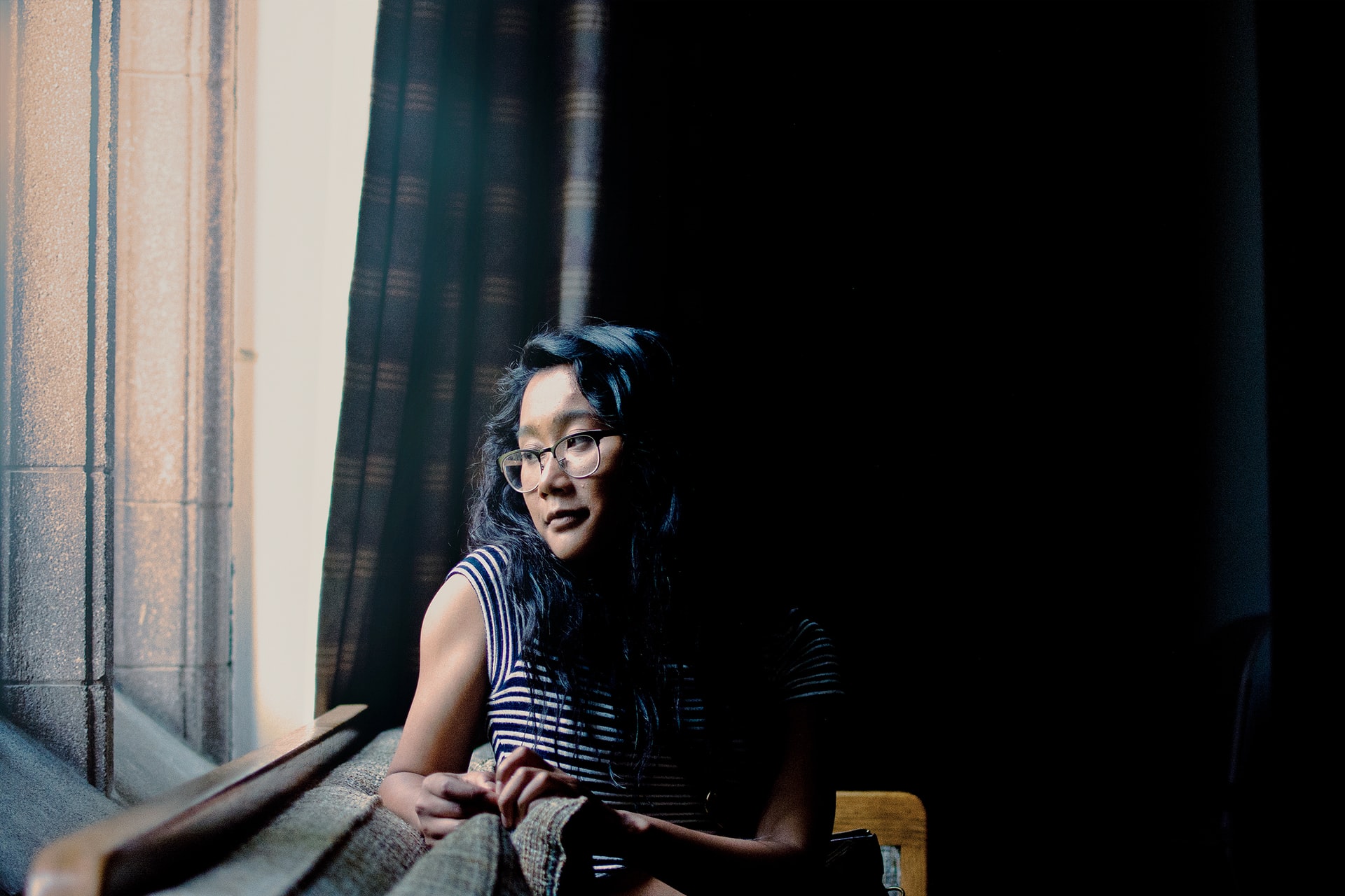 woman sitting on couch looking out the window