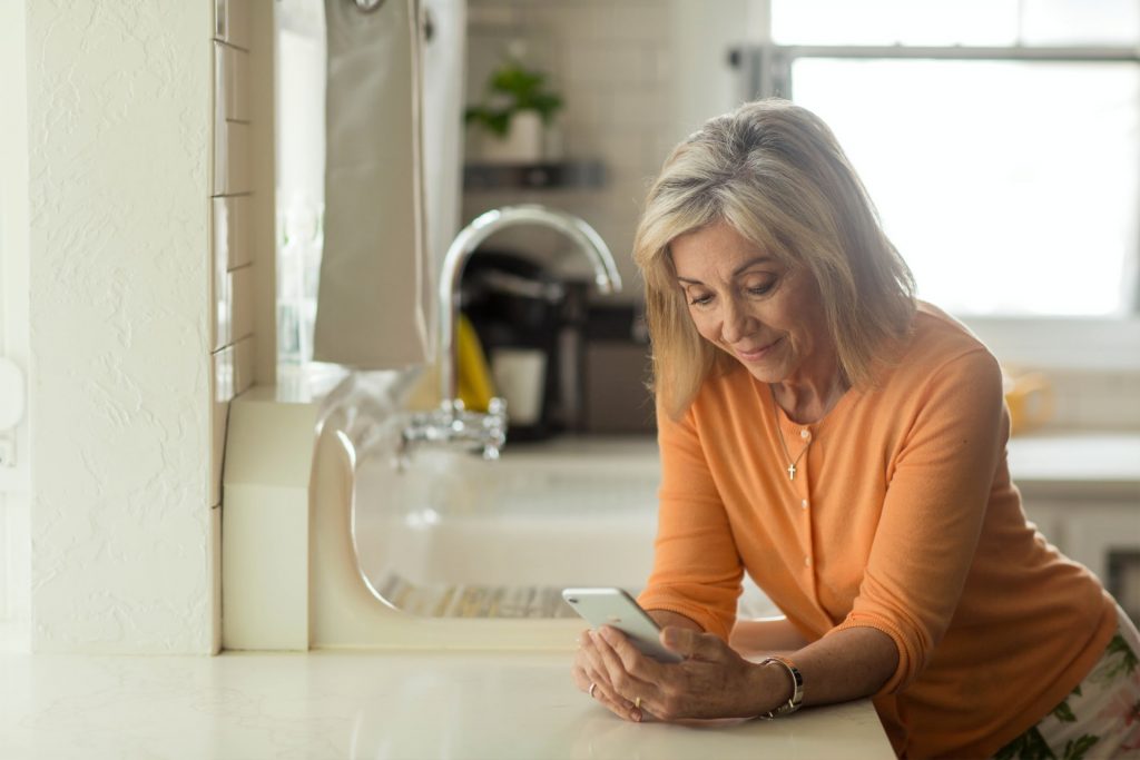 woman in orange shirt using a telehealth app