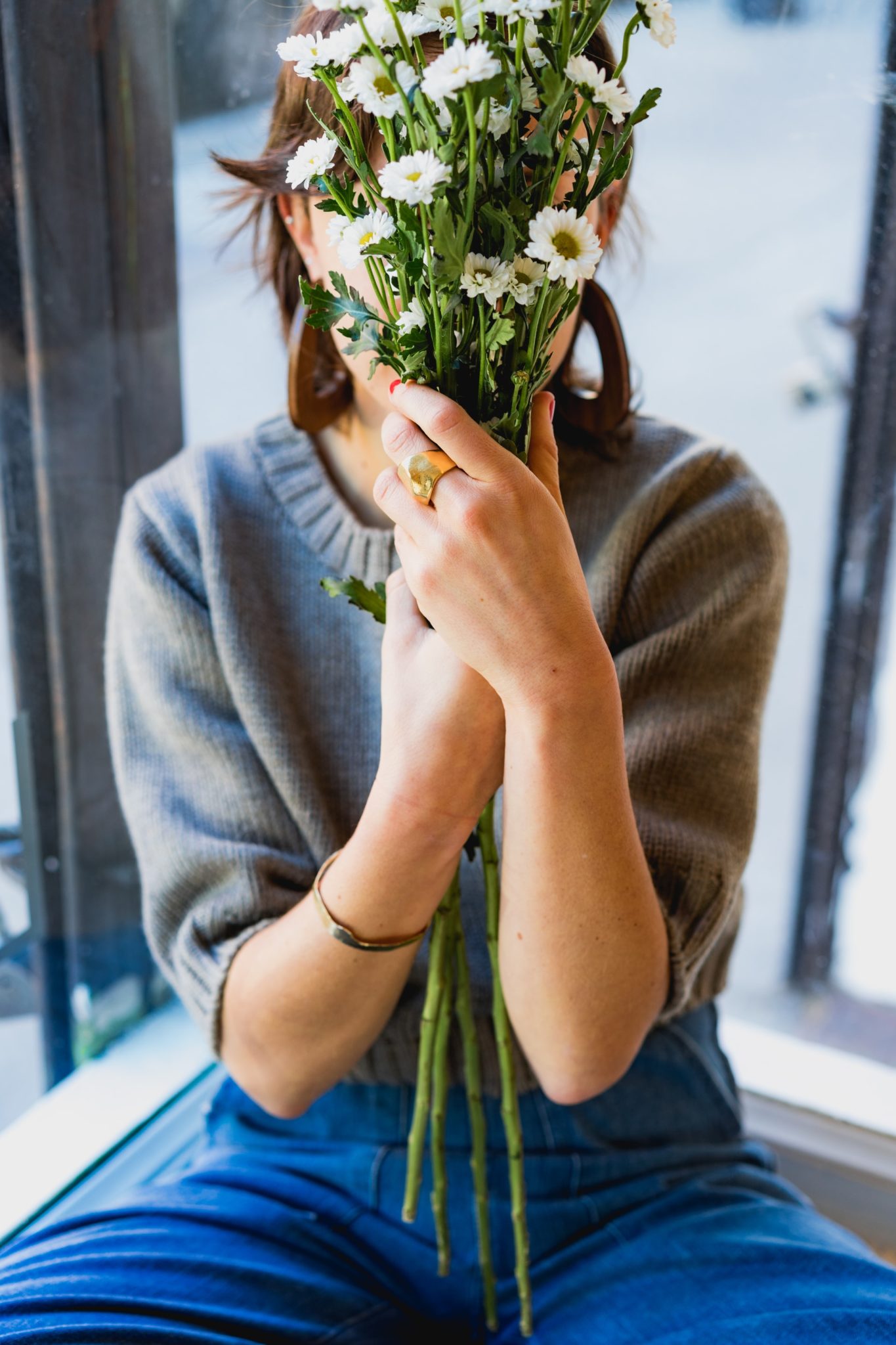 Woman holding flowers to hide her face