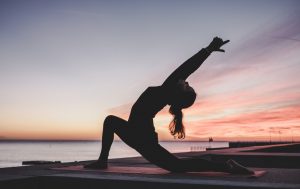 silhouettte of woman doing a yoga pose