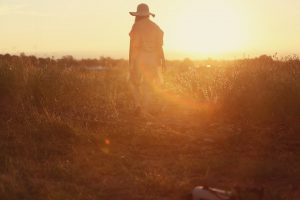 woman standing in field in golden light