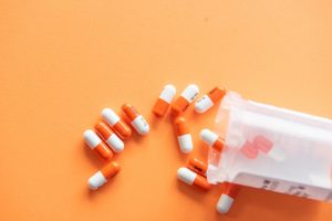 orange and white pills on an orange background