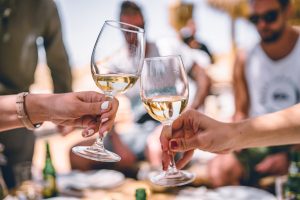 two people clinking wine glasses
