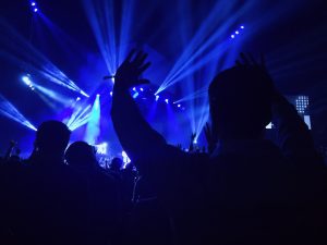 people waving their hands at a concert