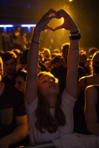 woman at a concert raising her hands