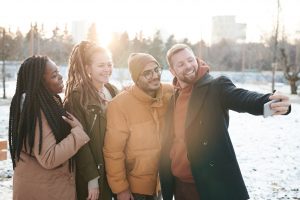 group of friends taking a photo outdoors in winter