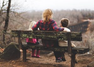 mother on a bench with kids overlooking valley