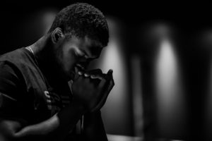 black and white photo man holding hands in prayer