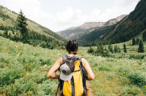 woman hiking among green mountains