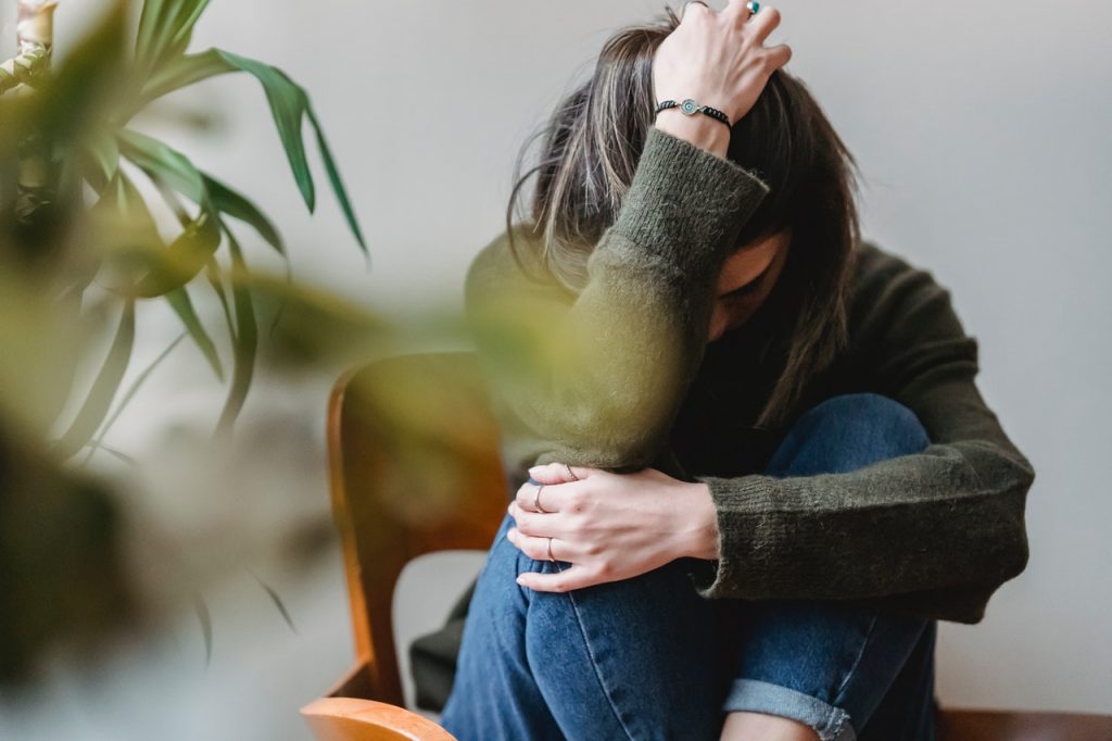 stressed woman huddled on chair