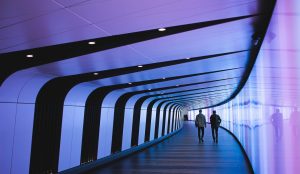 two people walking down a futuristic hallway