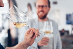 two people enjoying glasses of white wine