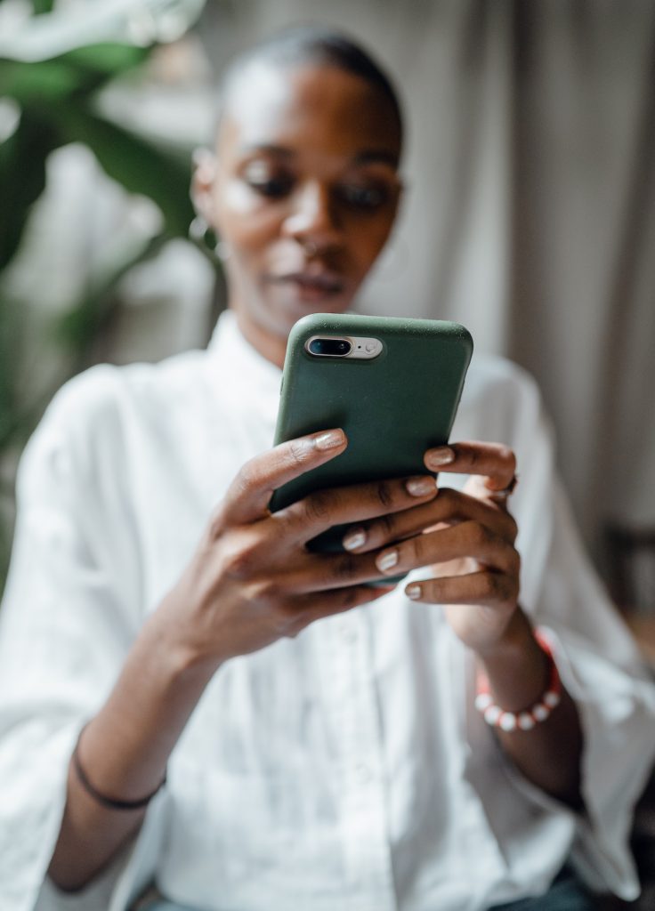 woman in white shirt using smartphone app