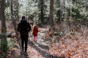man walking with child in the woods