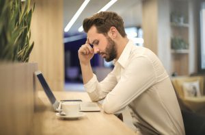 man with hangover working at the office