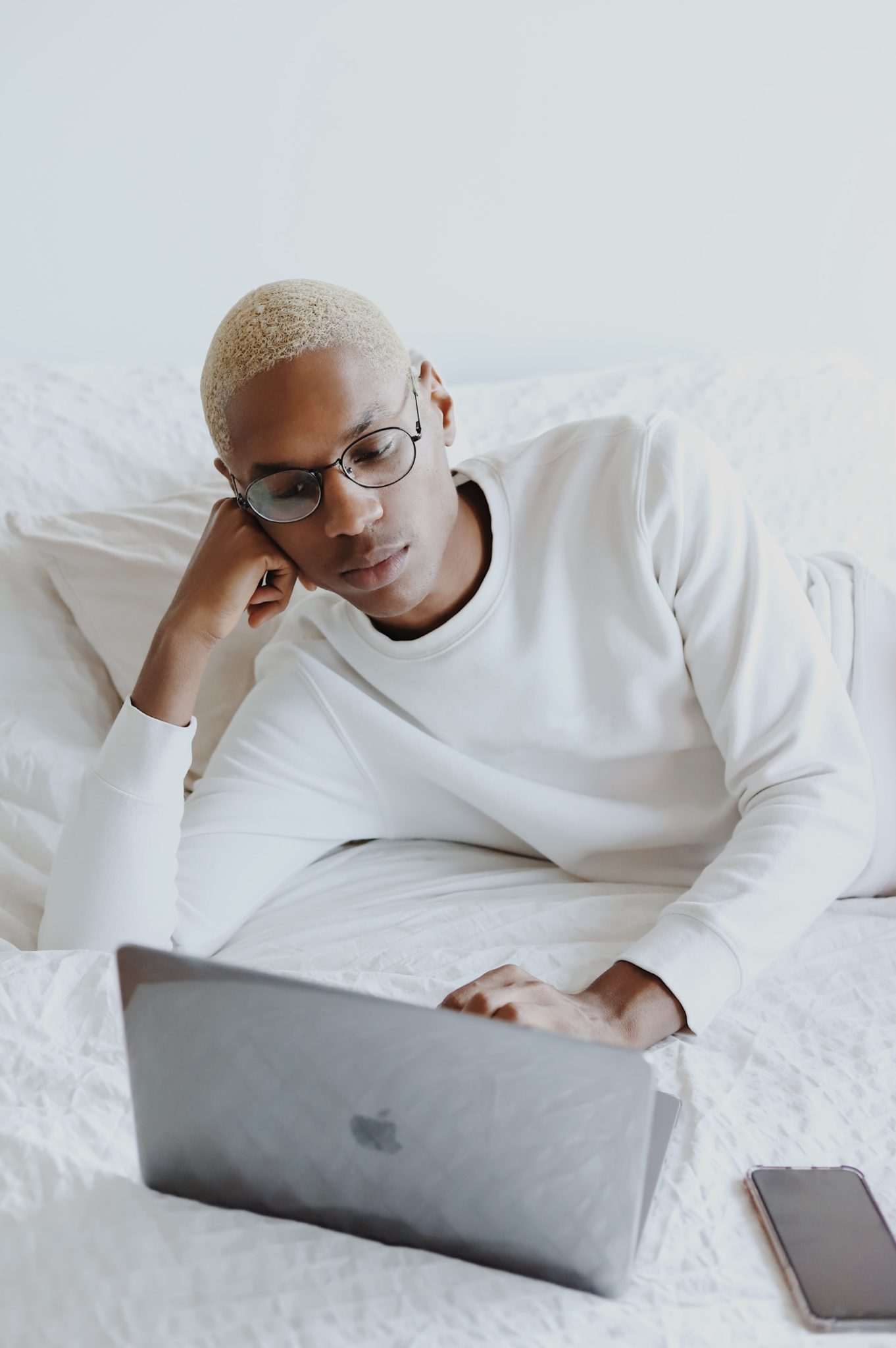 young man using a laptop on bed during quarantine