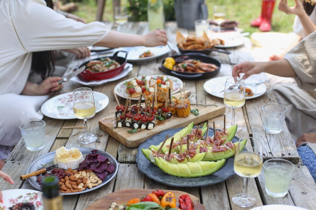 friends sharing food and drink at an outdoor table