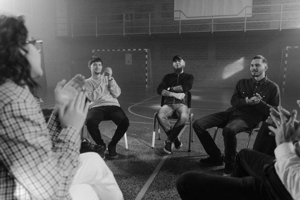 black and white photo of people sitting in a circle in a support group