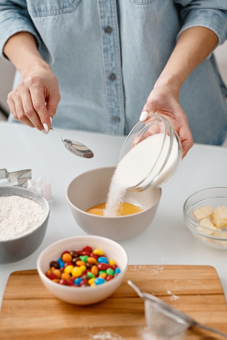 person pouring sugar in a bowl