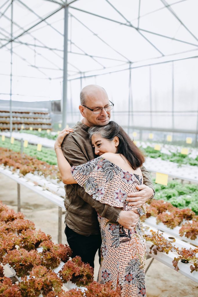man hugging woman in greenhouse