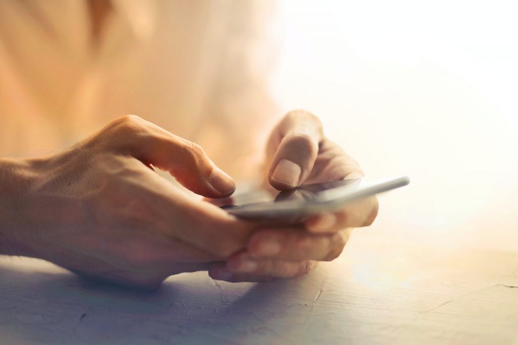 close up of hands using smartphone