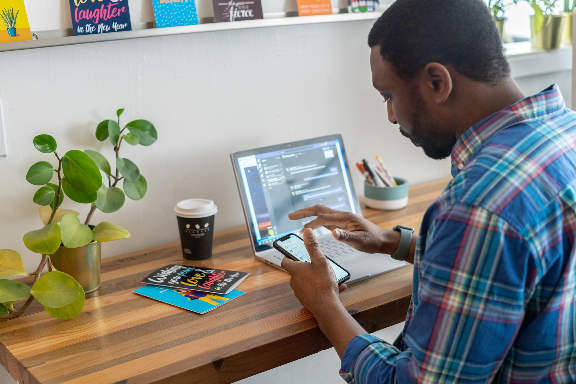 man checking his phone while working from home office