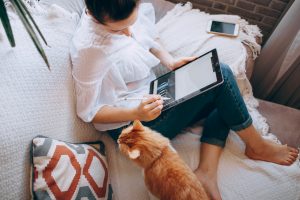 woman with cat working from the couch