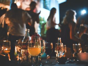 low light shot of beer and wine glasses on a table at a party