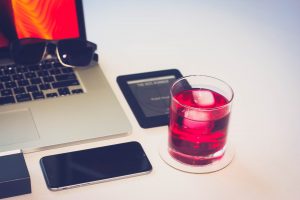 cocktail with laptop on table