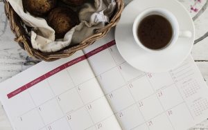 coffee cup and wicker basket with calendar on table