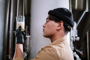 brewery worker examining a glass of beer