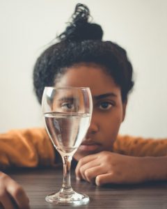 woman staring at glass on table