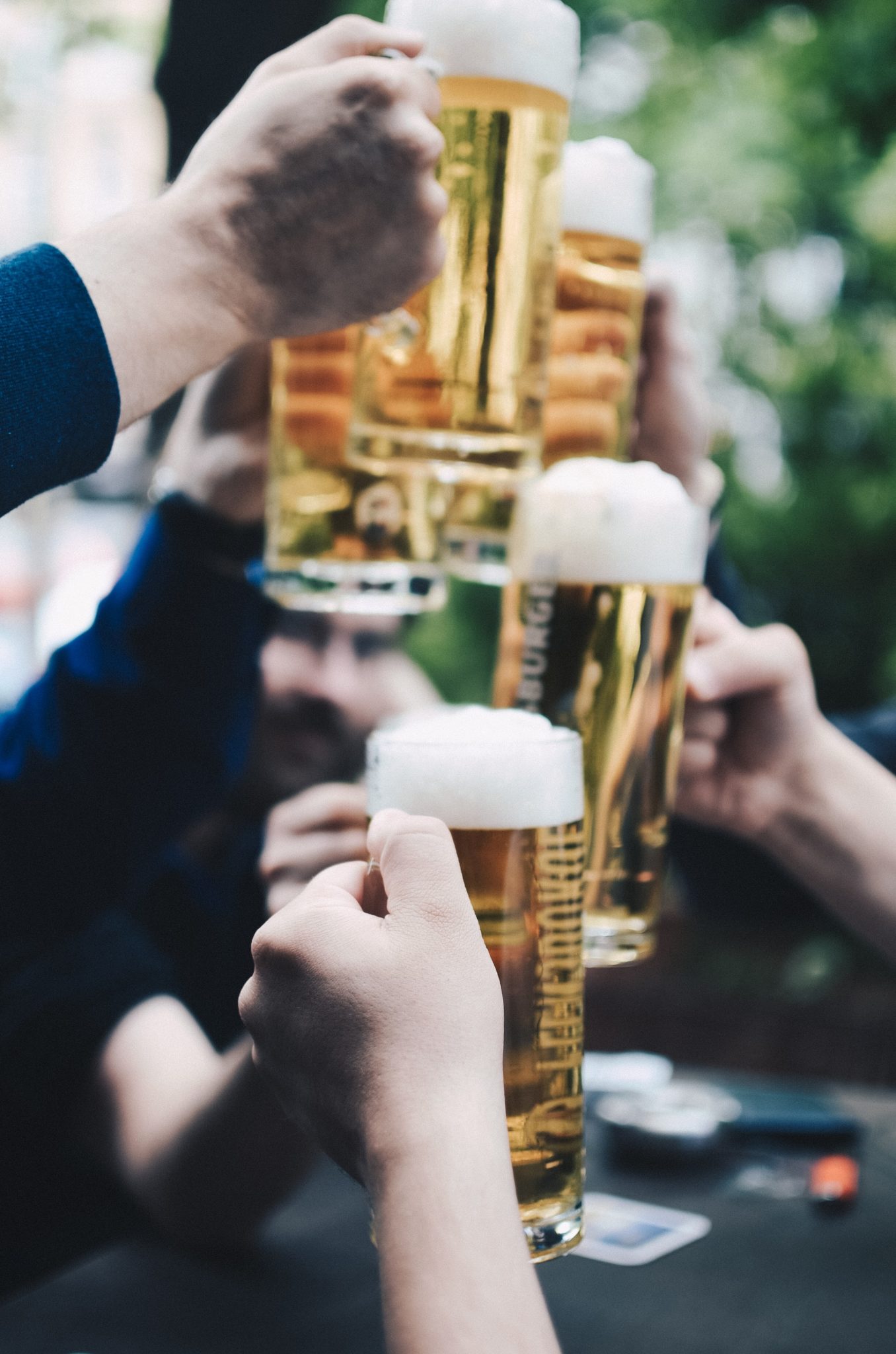 several hands raising beer pints on st paddy's day