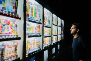 man staring at wall of vending machines