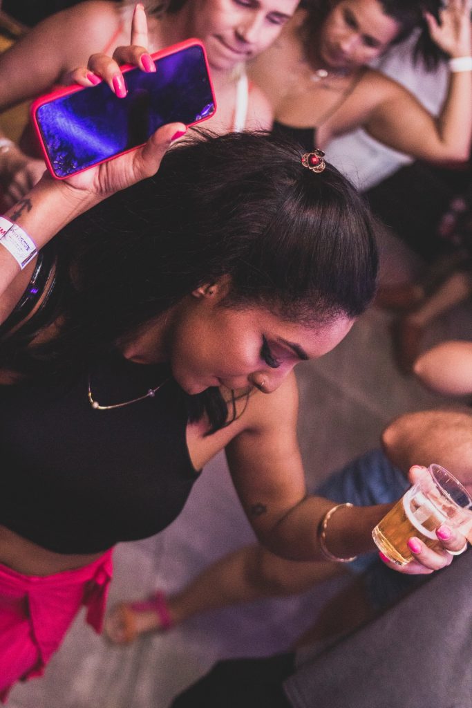 woman holding a drink and dancing at a party