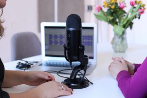 microphone in front of laptop with two people