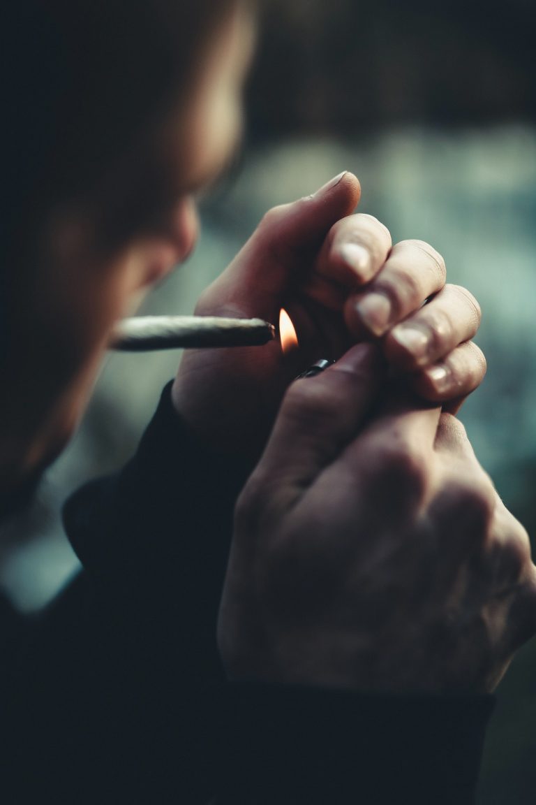 man lighting a joint dark shot