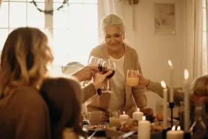 older woman rasing glasses with family at table