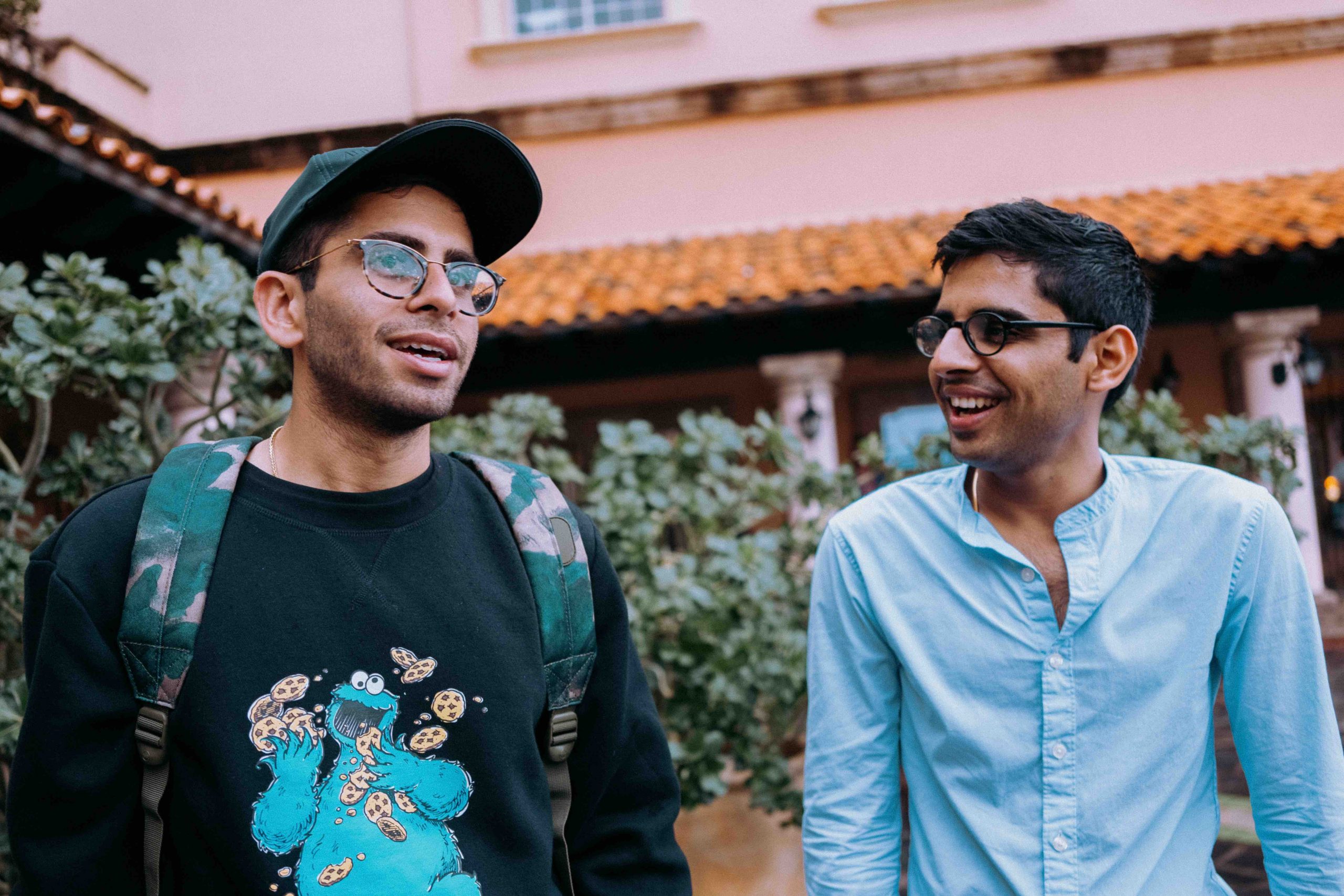 two men in different outfits smiling at each other