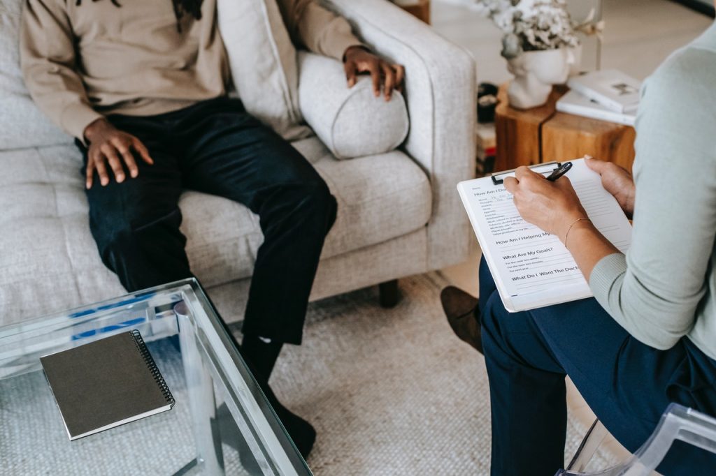 man sitting on couch talking to therapist