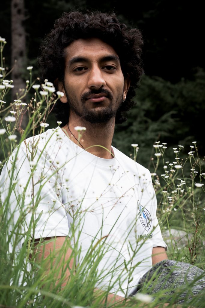 man sitting in a field of white flowers