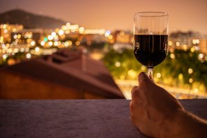 hand holding glass of wine overlooking evening view