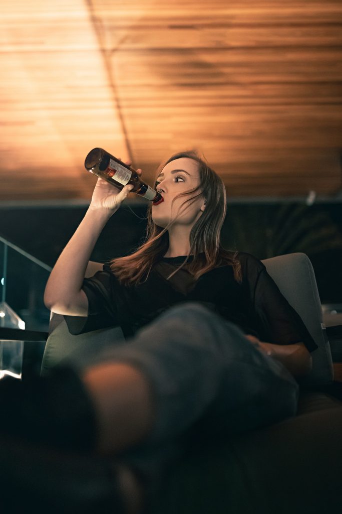 young woman swigging from a beer