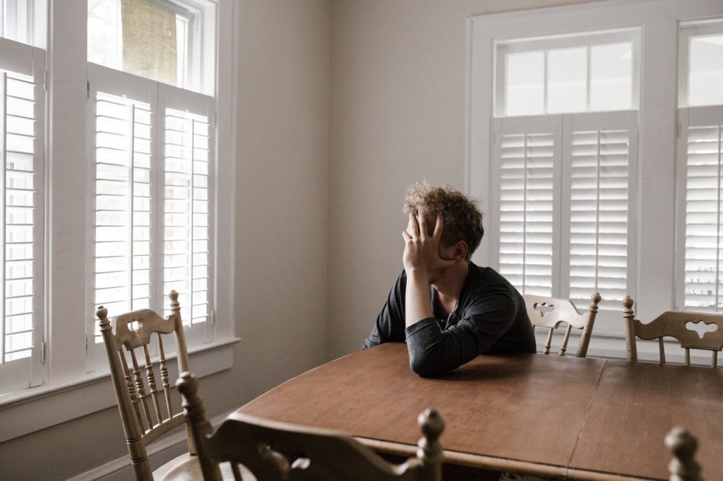 anxious man leaning on wooden table