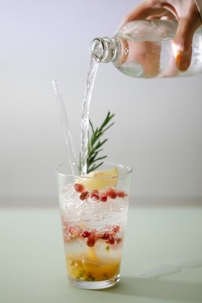 mixers being poured into a cocktail glass