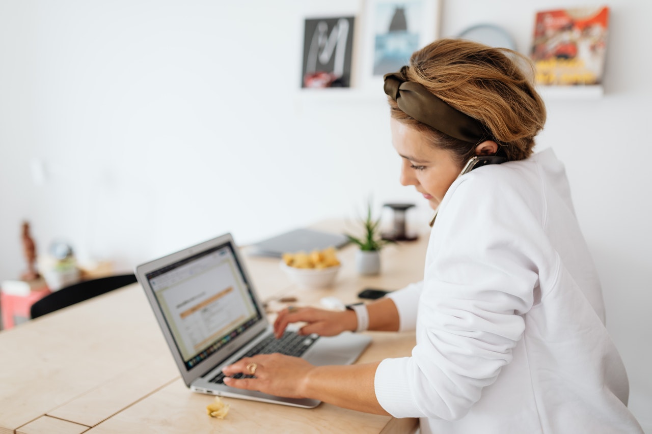 woman with laptop talking on smartphone