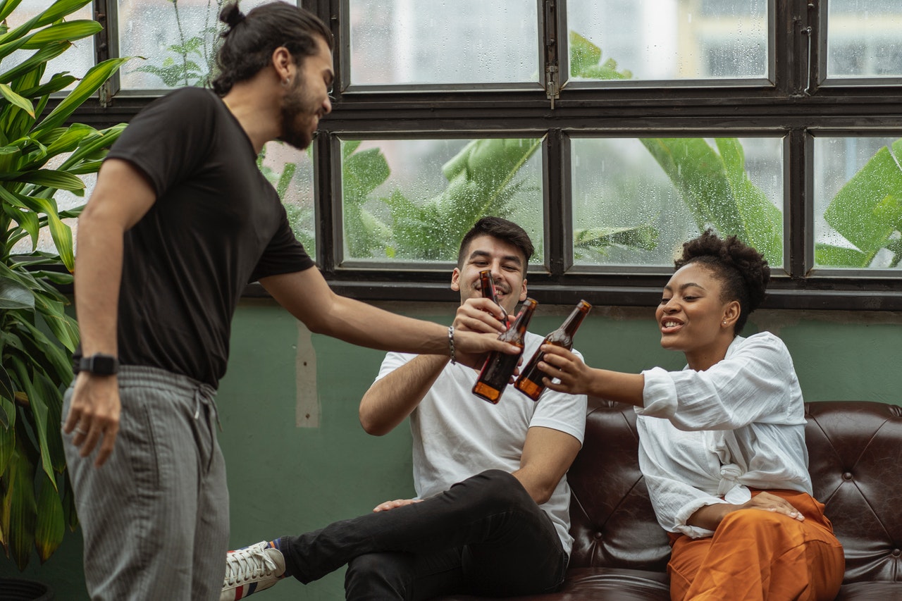 men and women drinking beer together outside