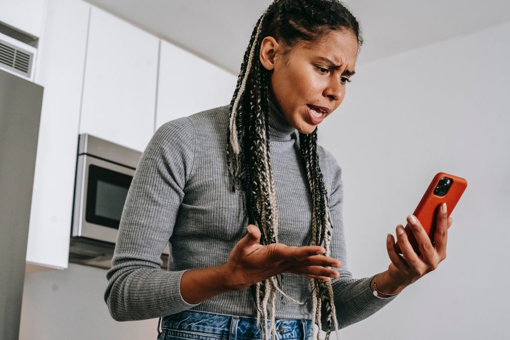 woman shouting into a cell phone in the kitchen